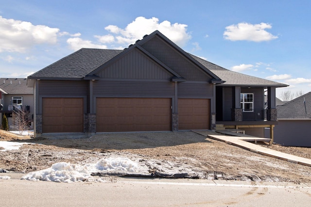 view of front of property featuring a garage, stone siding, and a shingled roof