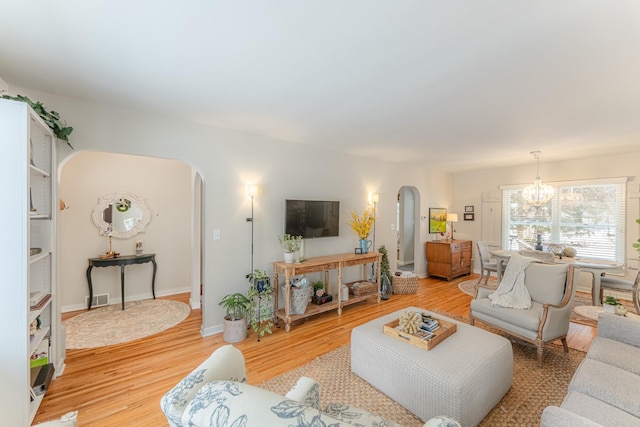 living room with light wood-type flooring and a chandelier