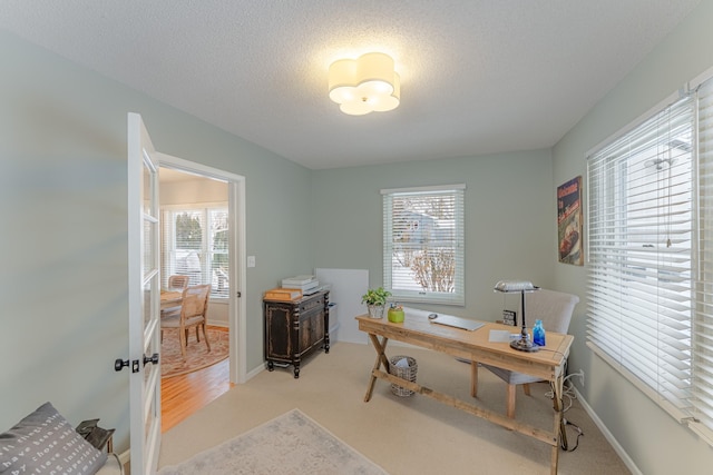 carpeted home office with a textured ceiling