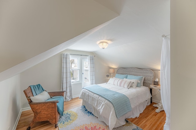 bedroom with vaulted ceiling and light hardwood / wood-style flooring