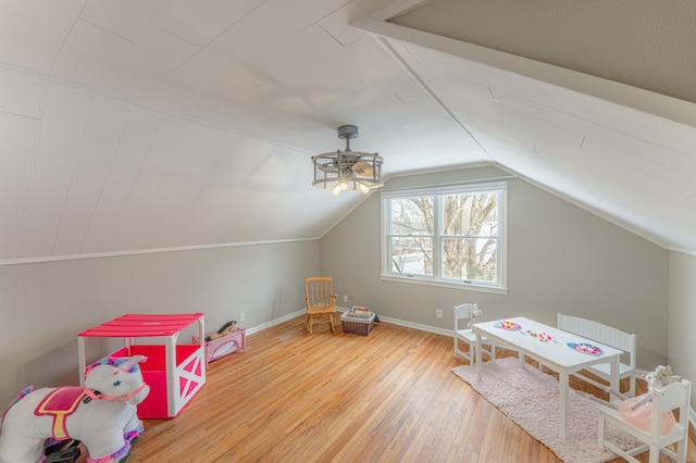 rec room featuring radiator heating unit, vaulted ceiling, and wood-type flooring