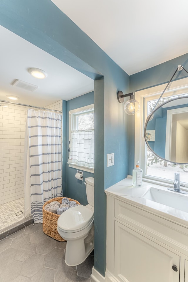 bathroom featuring toilet, vanity, and curtained shower