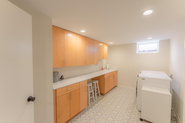 clothes washing area with independent washer and dryer and cabinets