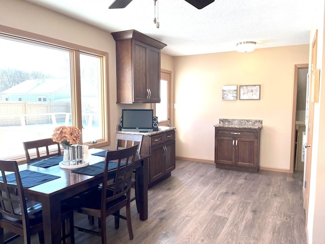 dining space featuring ceiling fan, dark hardwood / wood-style flooring, and a textured ceiling