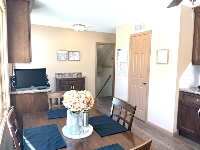 dining room with light hardwood / wood-style flooring and ceiling fan