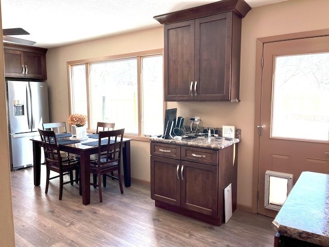 kitchen with hardwood / wood-style floors, stainless steel fridge with ice dispenser, and dark brown cabinets