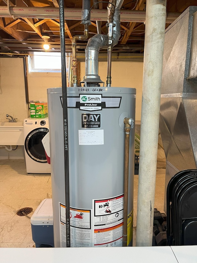 utility room with sink, water heater, and washer / dryer