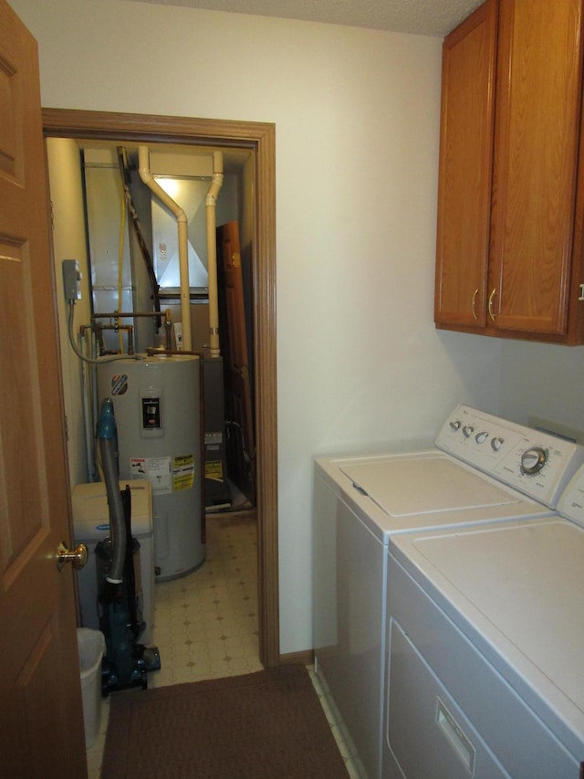 washroom with cabinets, washer and clothes dryer, and electric water heater