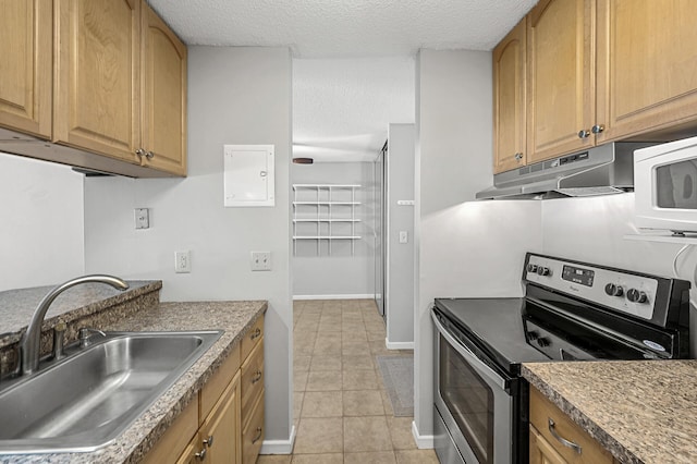 kitchen featuring light tile patterned flooring, stainless steel range with electric stovetop, sink, and a textured ceiling