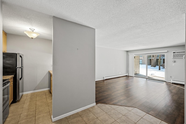 interior space with a textured ceiling, a wall mounted air conditioner, and baseboard heating