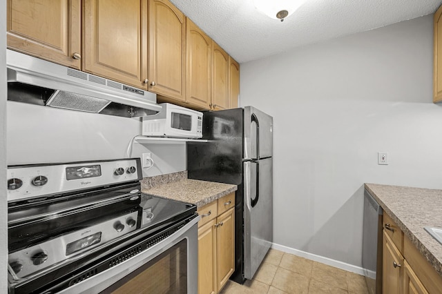 kitchen with a textured ceiling, under cabinet range hood, light countertops, and stainless steel appliances