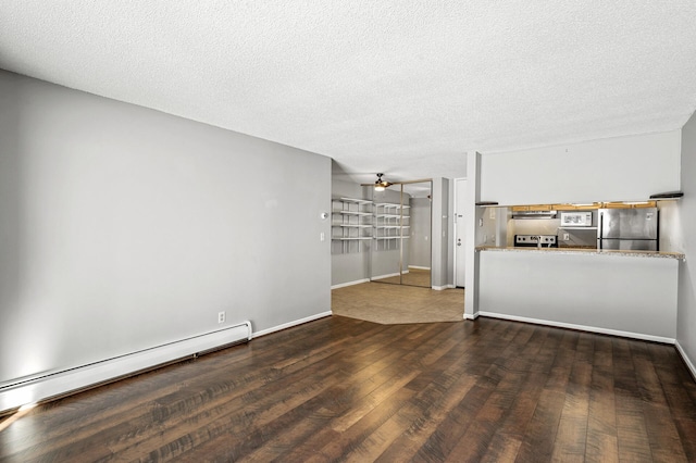 unfurnished living room with a textured ceiling, a ceiling fan, baseboard heating, hardwood / wood-style floors, and baseboards