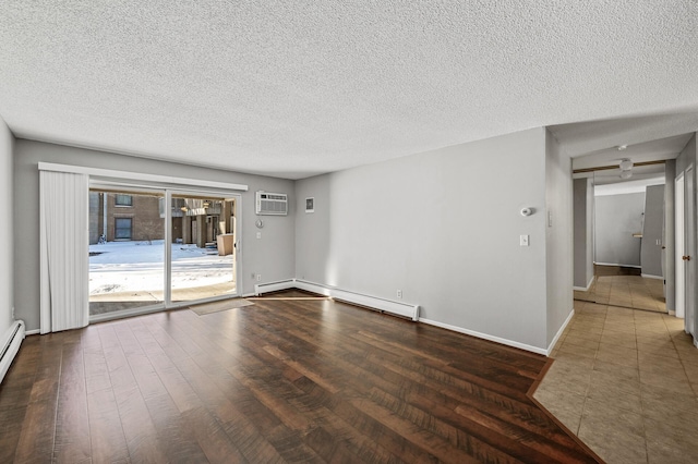 unfurnished room with a textured ceiling, wood finished floors, a baseboard heating unit, an AC wall unit, and baseboards