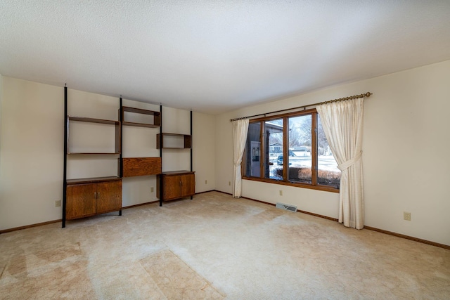 interior space with light carpet and a textured ceiling