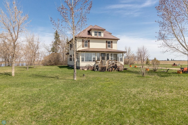 rear view of property featuring a lawn