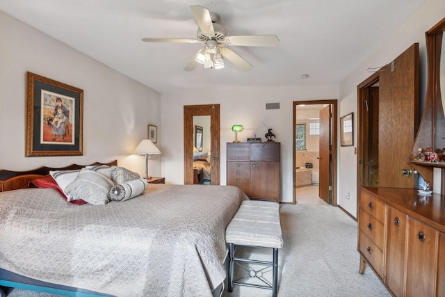 bedroom with ensuite bathroom, ceiling fan, and light colored carpet