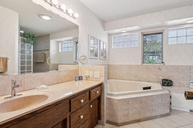 bathroom with tile patterned floors, tiled bath, vanity, and tile walls