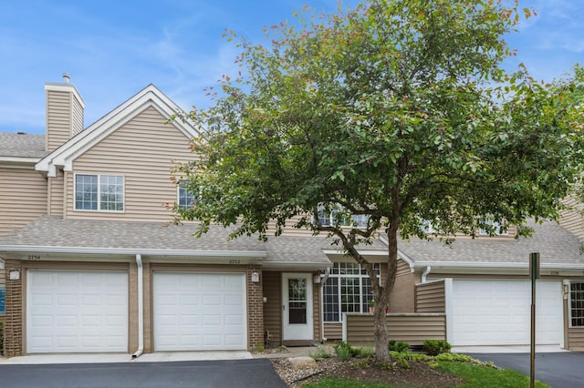 2752 Autumnwood Ln, Minnetonka, MN 55305 - view of front of house with brick siding, a shingled roof, an attached garage, and asphalt driveway