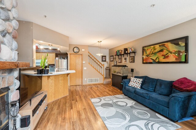 2752 Autumnwood Ln, Minnetonka, MN 55305 - living area featuring stairs, light wood-type flooring, and a stone fireplace