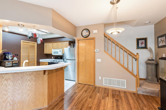 2752 Autumnwood Ln, Minnetonka, MN 55305 - kitchen featuring white appliances, light countertops, a peninsula, light wood-style floors, and a breakfast bar