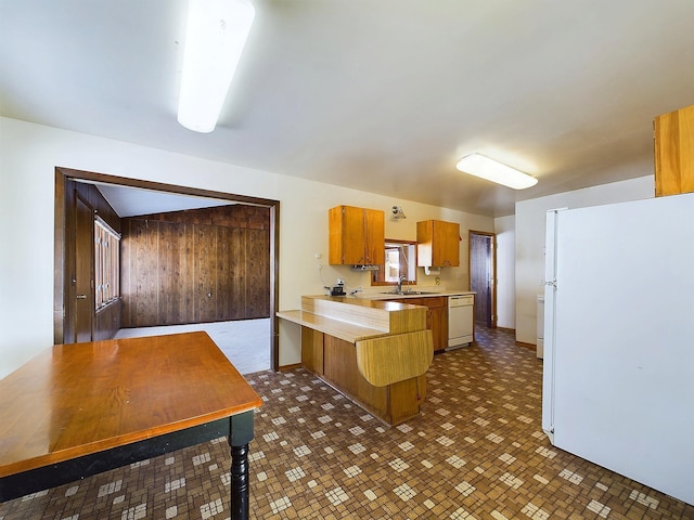 kitchen with sink, kitchen peninsula, and white appliances