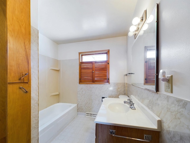 bathroom featuring tile walls, vanity, and tub / shower combination