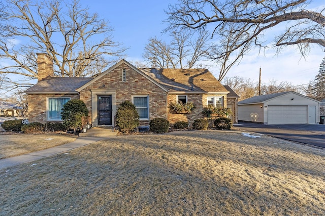 view of front of home featuring a front yard, an outdoor structure, and a garage