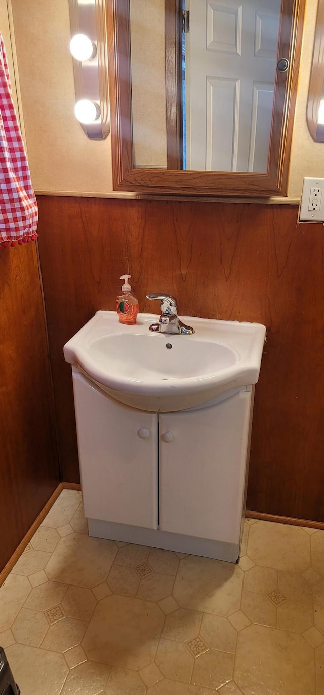 bathroom featuring wooden walls and vanity