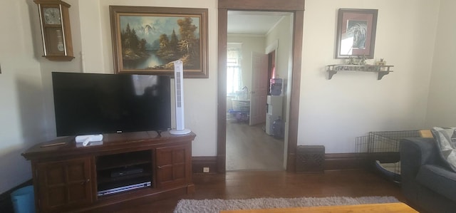 interior space with crown molding, baseboards, and wood finished floors