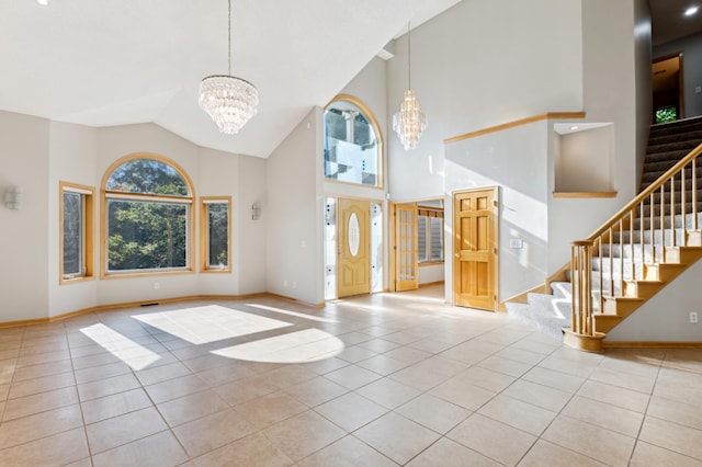 tiled entryway with high vaulted ceiling and a chandelier