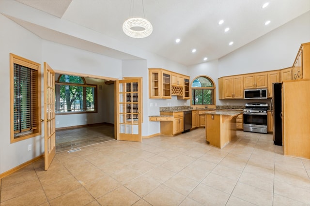 kitchen featuring stainless steel appliances, a center island, decorative light fixtures, light tile patterned floors, and a kitchen breakfast bar