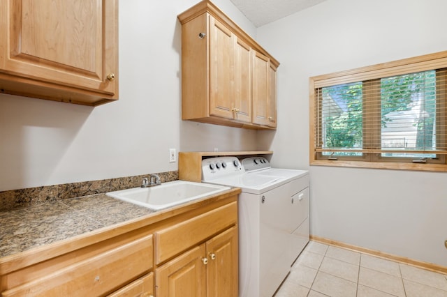 laundry area featuring cabinets, washer and dryer, sink, and light tile patterned floors