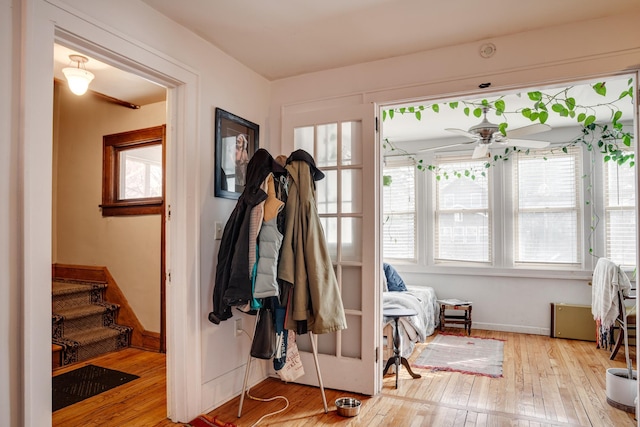 interior space with stairs, baseboards, a ceiling fan, and hardwood / wood-style flooring