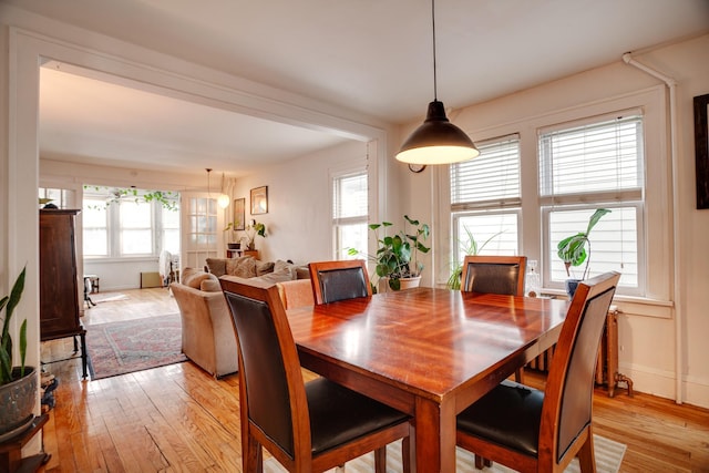 dining space with light wood-type flooring and baseboards