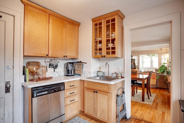 kitchen featuring a sink, light brown cabinets, light countertops, and stainless steel dishwasher