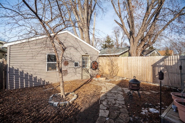 view of yard with a fenced backyard and a fire pit