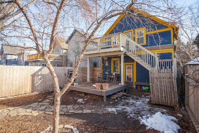 rear view of property with stairway, a fenced backyard, and a wooden deck