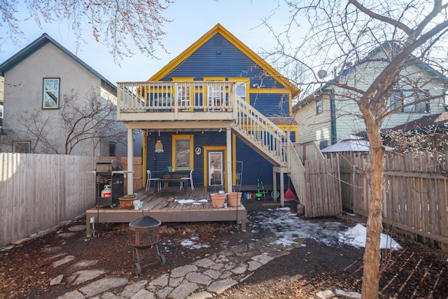 rear view of house featuring stairway, a fenced backyard, and a wooden deck