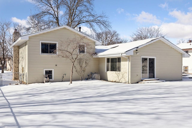 view of snow covered back of property