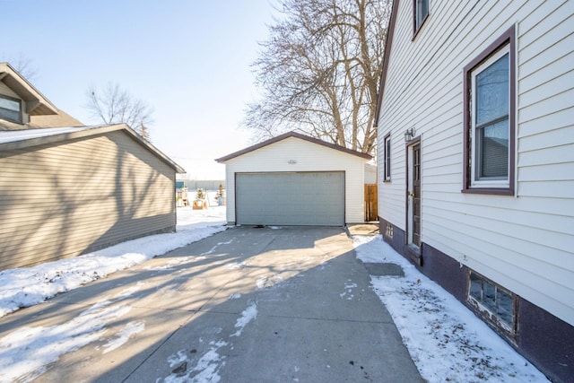 view of snow covered exterior with a garage and an outdoor structure