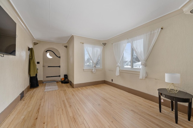 foyer featuring ornamental molding and light hardwood / wood-style flooring