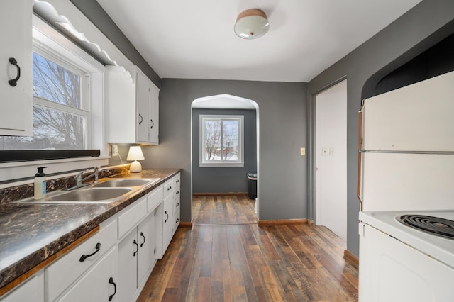 kitchen featuring refrigerator, electric range, dark hardwood / wood-style flooring, sink, and white cabinets