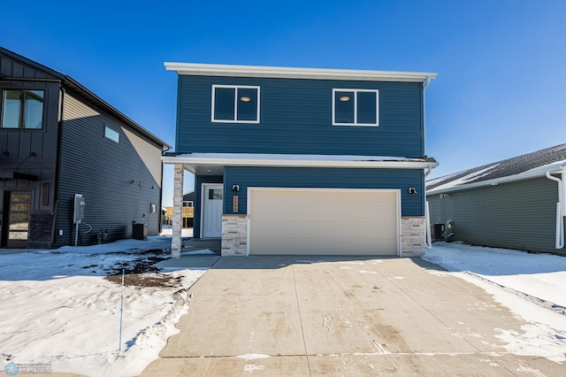 view of front of home with stone siding, an attached garage, and concrete driveway