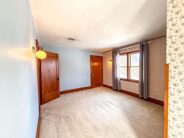 unfurnished room with wallpapered walls, visible vents, baseboards, and light carpet