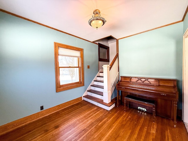 stairs with crown molding, baseboards, and wood finished floors