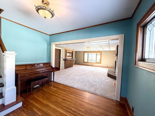 interior space featuring stairs, wood finished floors, baseboards, and ornamental molding