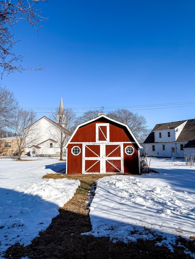 snow covered structure with an outbuilding and a barn