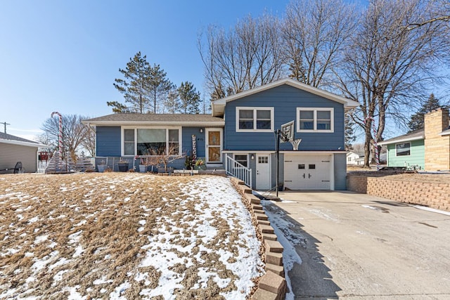 split level home featuring concrete driveway and an attached garage