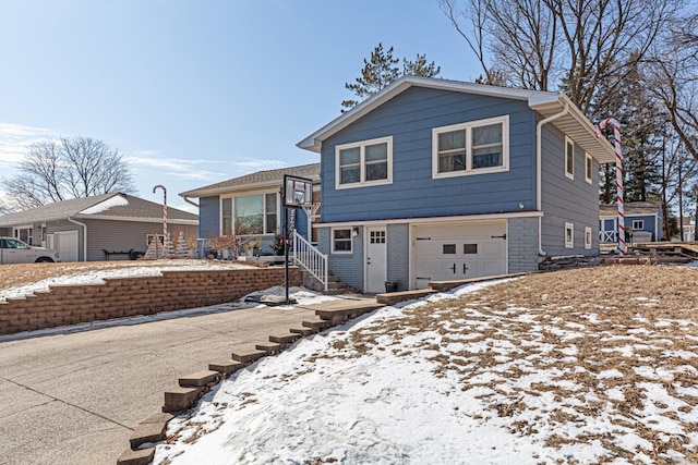 tri-level home featuring an attached garage and brick siding