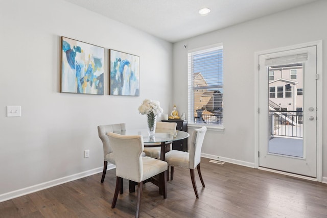 dining room with dark wood-style floors, visible vents, and baseboards